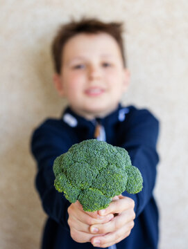 Portrait of a boy with broccoli