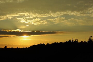 Obraz premium sunset over the forest with beautiful clouds