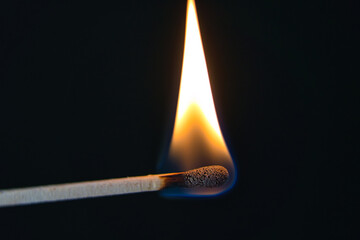 A selective focus of a match on fire on black background