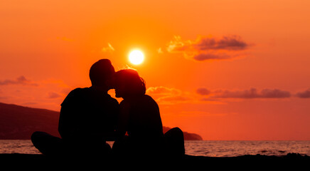 Harmony between couple at the beach, silhouette during sunset, lovers.