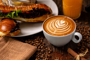 Good morning in rustic style, latte espresso, coffee beans, tasty snack and orange juice