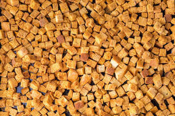 Square-shaped bread crumbs. Oven-fried golden brown bread crumbs. Background.