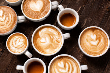 Bunch of espresso coffee cups with latte art placed on a wooden table