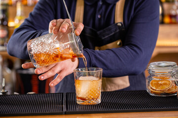 Bartender serving a refreshment liquor drink on the bar