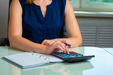 Accountant woman. Professional Chartered Accountant Woman. Accountant doing tax. Calculator symbolizes accounting or auditing services. Calculator and notepad on auditor desk. Auditor hands with pen