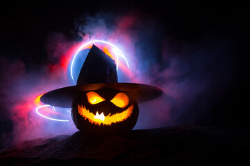 Fototapeta premium Halloween pumpkin smile and scary eyes for party night. Close up view of scary Halloween pumpkin with eyes glowing inside at black background.