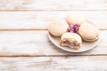 Meringues cakes on a white wooden background. Side view, copy space.