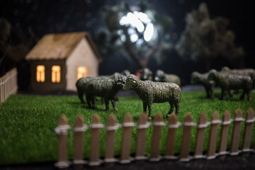 Sheep in the farm. Farm (village) life concept. Decorative toy figures at night. Selective focus
