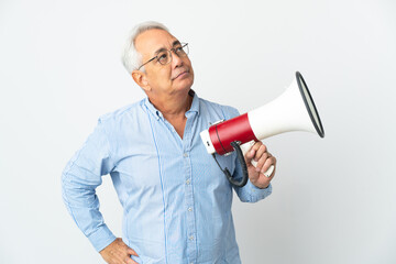 Middle age Brazilian man isolated on white background holding a megaphone and thinking