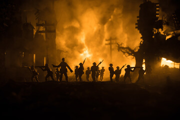 War Concept. Military silhouettes fighting scene on war fog sky background, World War Soldiers Silhouette Below Cloudy Skyline At night. Battle in ruined city. Selective focus