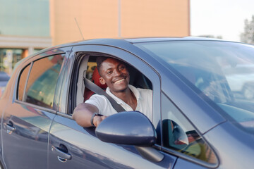 An African-American man driving a car. Human emotions