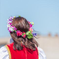 Naklejka premium The girl weaved flowers and a wreath into her hair.