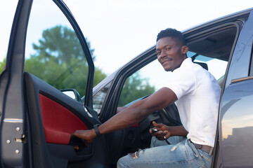 A happy African-American man holds the car keys. Car sales and rentals