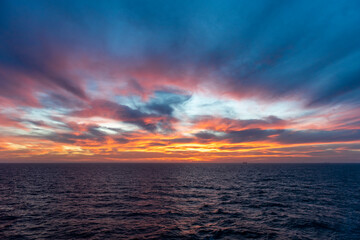 Sunset at sea. Seascape, blue sea.  Calm weather. View from cargo vessel.