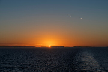 Sunset at sea. Seascape, blue sea.  Calm weather. View from cargo vessel.