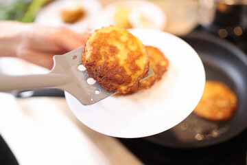 Delicious golden yellow potato pancakes in frying pan