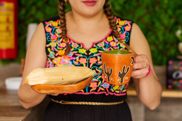 Unrecognizable woman with a traditional Mexican tamal and atole