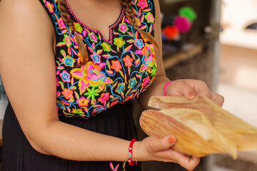 Unrecognizable woman taking a traditional Mexican tamal