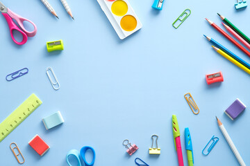 Flat lay composition with school supplies on blue background. Back to school concept. Top view, overhead.