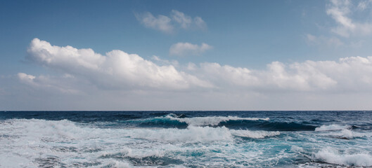 Fototapeta na wymiar Sea waves crash on the rough rocky shore