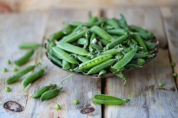 Green peas in a bowl on a wooden surface. Healthly food. Vegan diet concept.