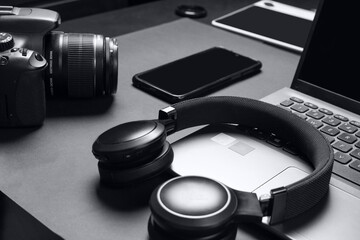 headphones, camera, smartphone and notebook on a black background