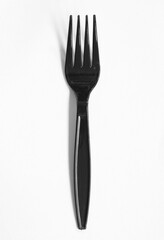 Plastic black fork isolated on black background
