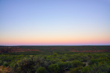 Sunset view of a pink sky over trees in Kalbarri National Park in the Mid West region of Western Australia