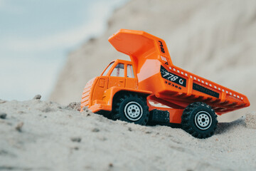 Truck in a sand quarry. Large excavator loads rock with iron or bauxite mining dump truck in a quarry against the sky