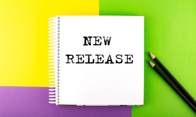 Minimal work space : sketchbook on the colorful background with NEW RELEASE text