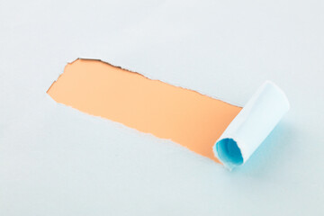Ripped long strips on blue paper leaks out yellow