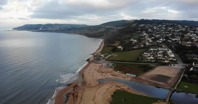 Aerial Over Charmouth Beach With Waves Gently Breaking. Slow Dolly Forward
