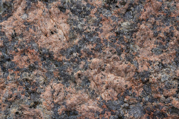 Granite texture. Natural pink granite with a grainy pattern. Stone background. Solid rough surface of rock. Durable construction and decoration material. Close-up.