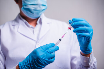 Fototapeta premium Doctor holding tube with Coronavirus vaccine and syringe. Healthcare And Medical concept.