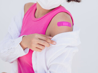 Vaccinations, bandage on vaccinated people's arm concept. Pink bandage after vaccination treatment...