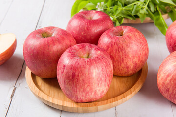 Ripe red apples on white wooden background
