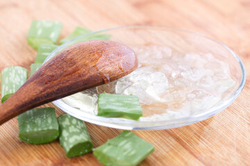 Peeled aloe vera meat on the plate and wooden spoon