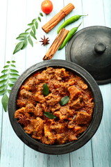 Indian beef curry roast, cooked in in earthen ware, clay pottery. top view.