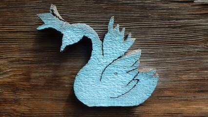 Wooden swan painted blue on wooden background