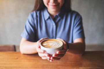 Closeup image of a woman holding a cup of hot coffee