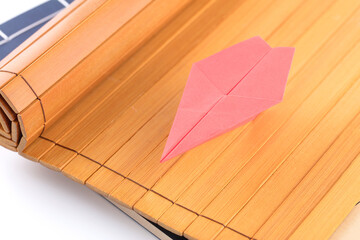 Unfolded bamboo slips and paper airplane on top
