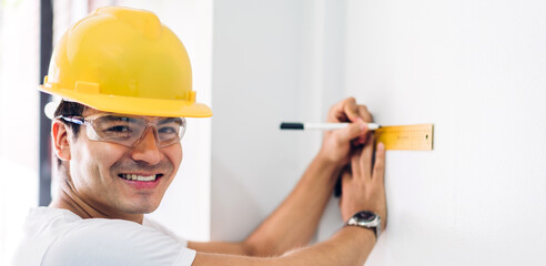 Young construction engineer man in a yellow helmet working and looking job for planning project at building home site