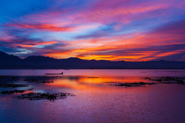 Fototapeta na wymiar Dramatic sunset sky over the lake and mountains.