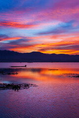 Fototapeta na wymiar Dramatic sunset sky over the lake and mountains.