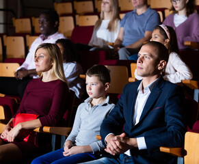 caucasian family sitting at premiere in theatrical hall