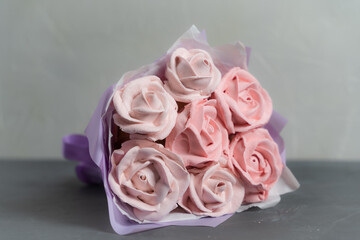 Fototapeta premium Bouquet of marshmallows. Marshmallow roses and tulips are collected in a bouquet. Packed in paper and gift box. A sweet gift for loved ones. A gift to your beloved.