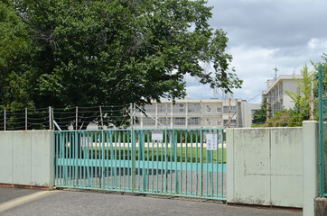 日本の学校の門は、警備中で閉じられています。