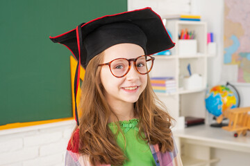 Elementary school learning and kids concept. Little student in graduation cap.