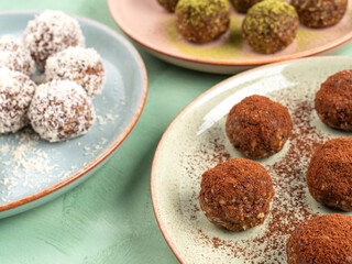 Three different taste energy balls in dishes, cocoa, coconut, matcha
