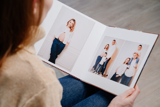 woman watches photobook from photo shoot of family.
